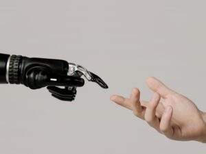 A human hand reaching to touch a bionic prosthetic hand on a white background.